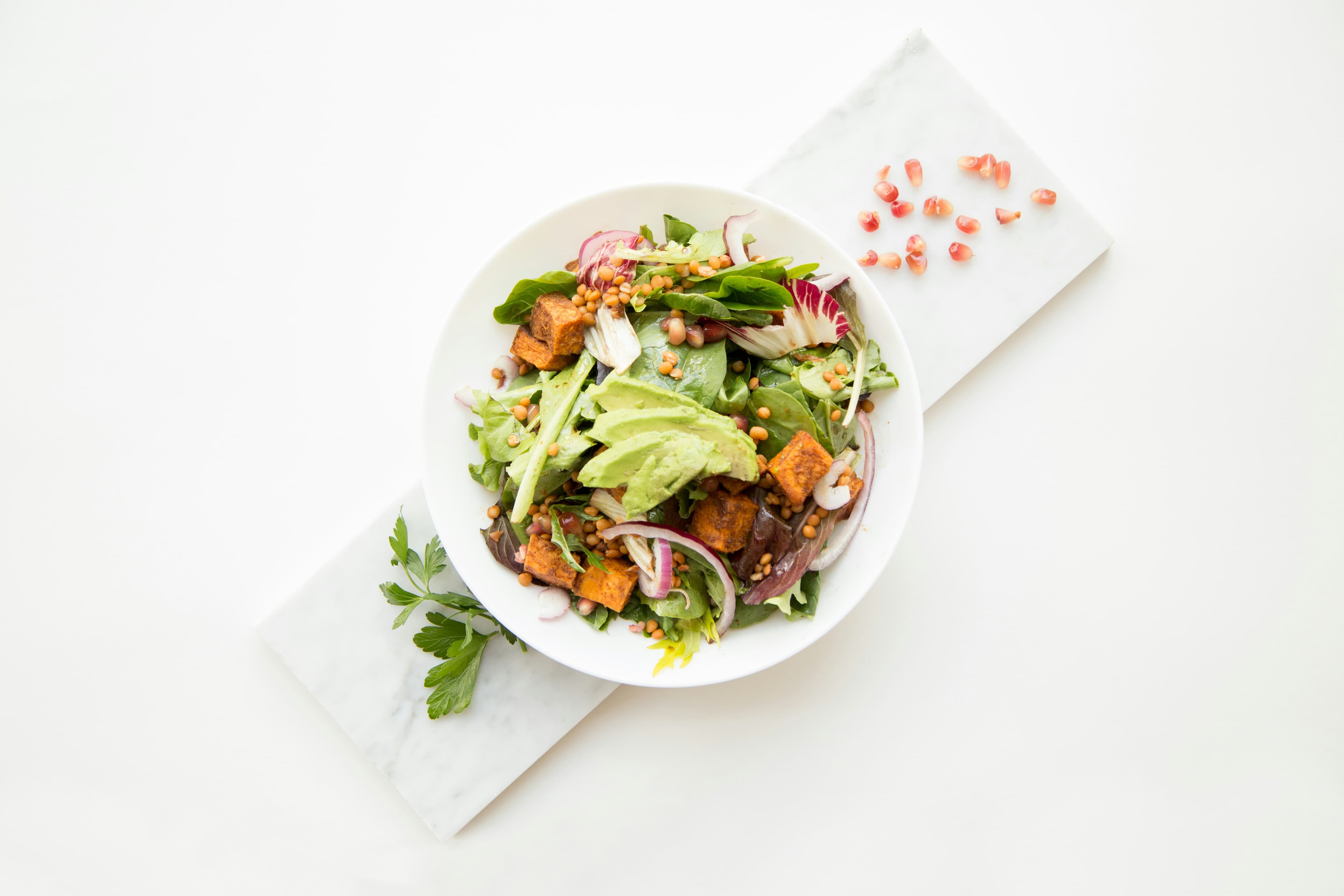 Cooked food with sliced vegetables in white bowl